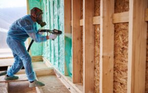 worker applying spray foam insulation
