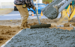 Man in work boots leveling concrete as its poured
