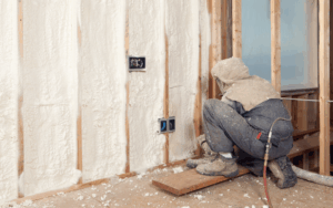 Person installing spray foam in home wall