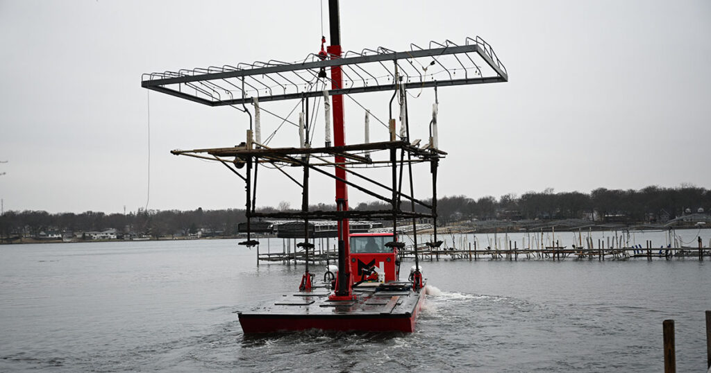ShoreStation boat hoist holding a boat at an Iowa Great Lakes dock.