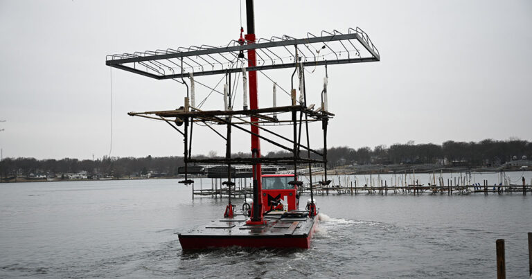 ShoreStation boat hoist holding a boat at an Iowa Great Lakes dock.