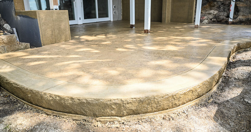 Finished stamped and colored concrete patio in a northwest Iowa backyard.